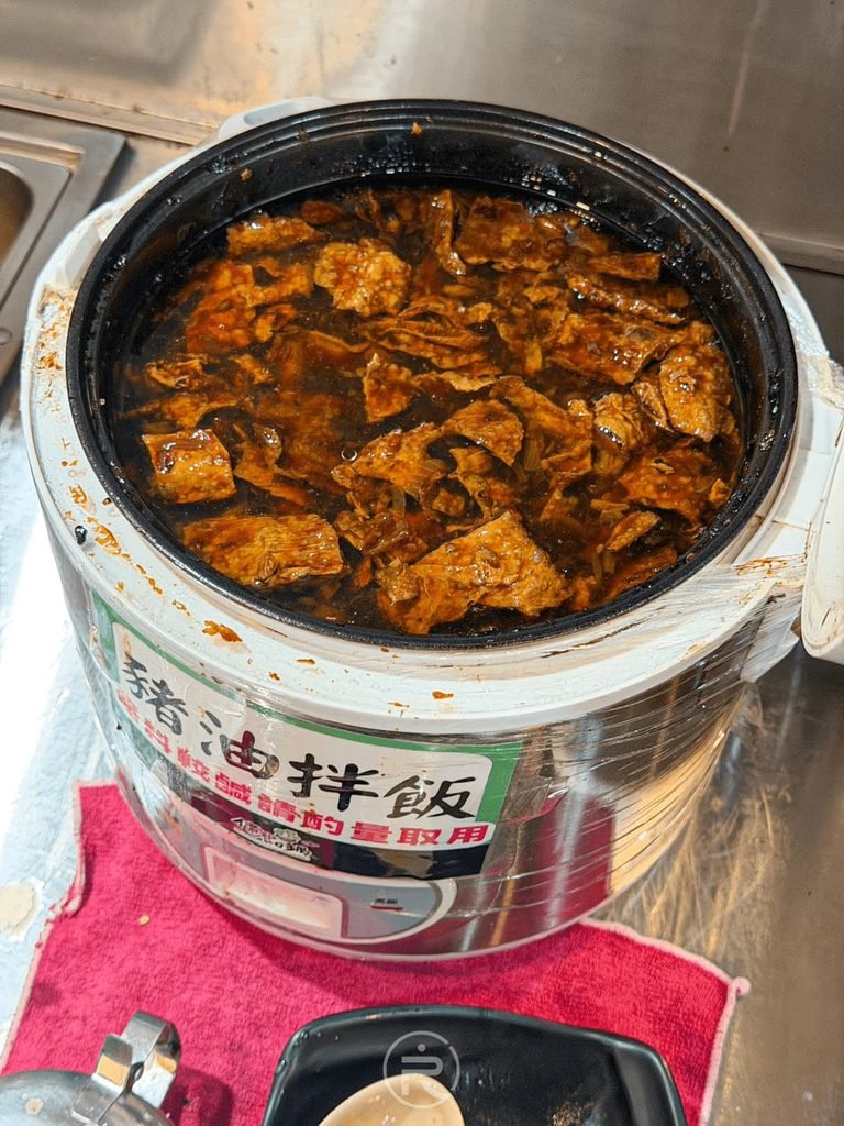 [豬油拌飯鍋內餡]： 冒著熱氣的豬油拌飯鍋，裡面有滿滿的大塊滷豆腐與豆皮料。