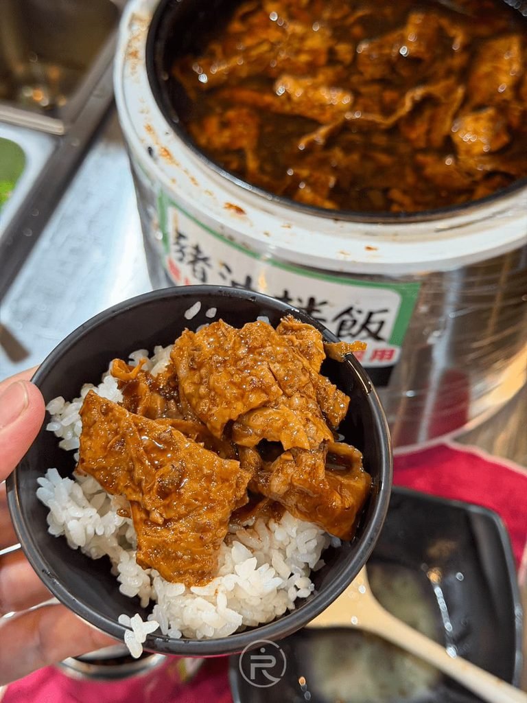 [大匙舀滷肉豆腐]： 手持一碗淋上豐富滷汁與軟嫩油豆腐塊的古早味拌飯。