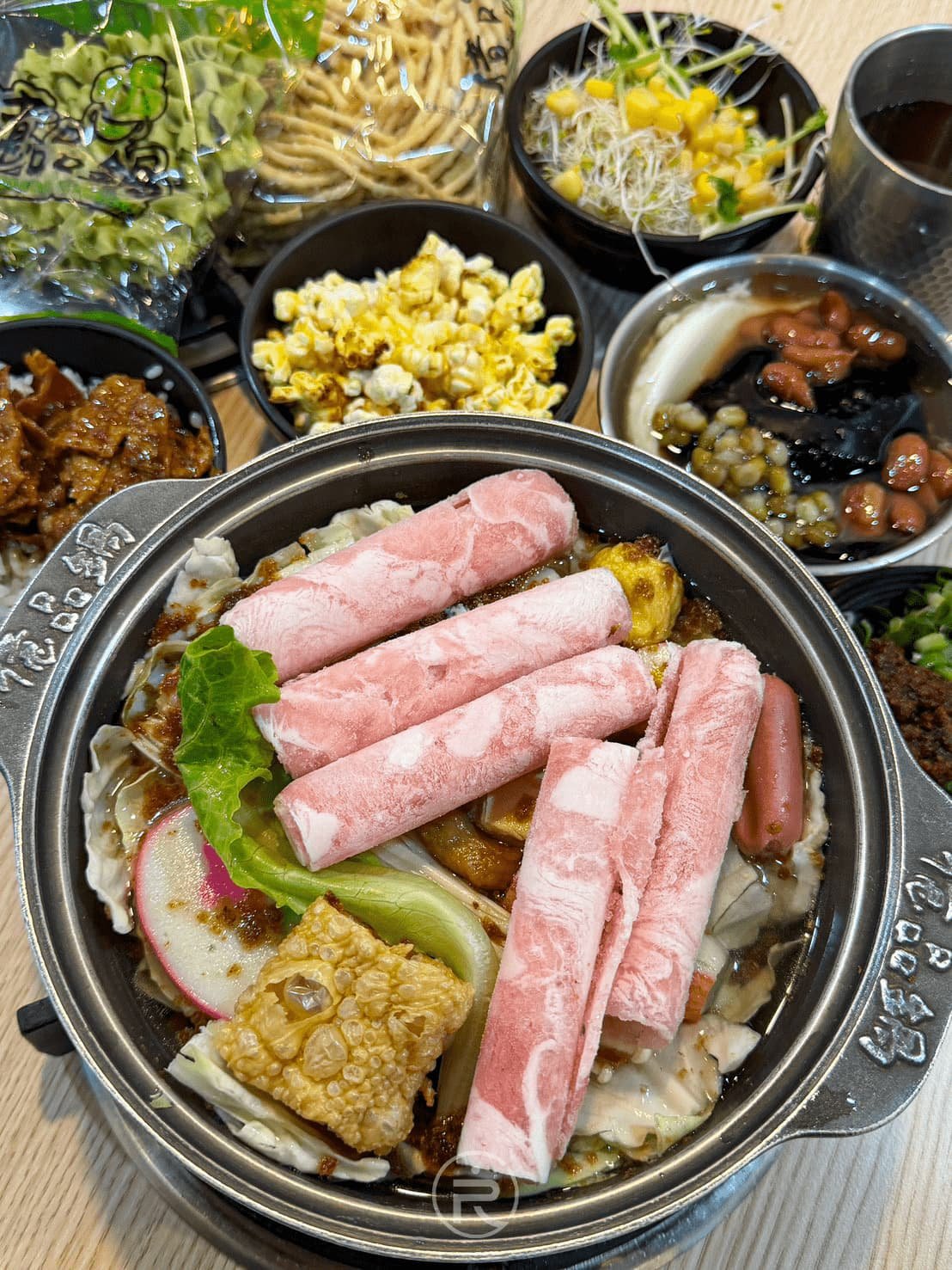 億品鍋豐原店 [主鍋與附餐俯拍]： 汕頭沙茶鍋搭配整桌自取豐盛副餐的澎湃視角。
