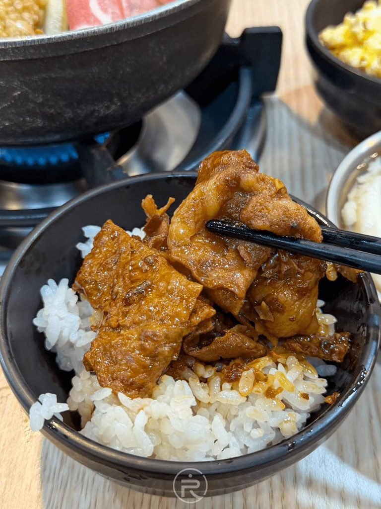  [筷夾滷豆腐拌飯]： 夾起白飯上吸飽滷汁的入味大塊豆腐，香氣撲鼻。