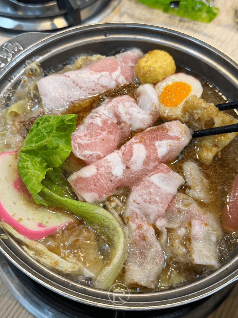 [火鍋滾沸開煮]： 瓦斯爐上正咕嘟咕嘟滾沸的沙茶鍋，肉片逐漸熟成。