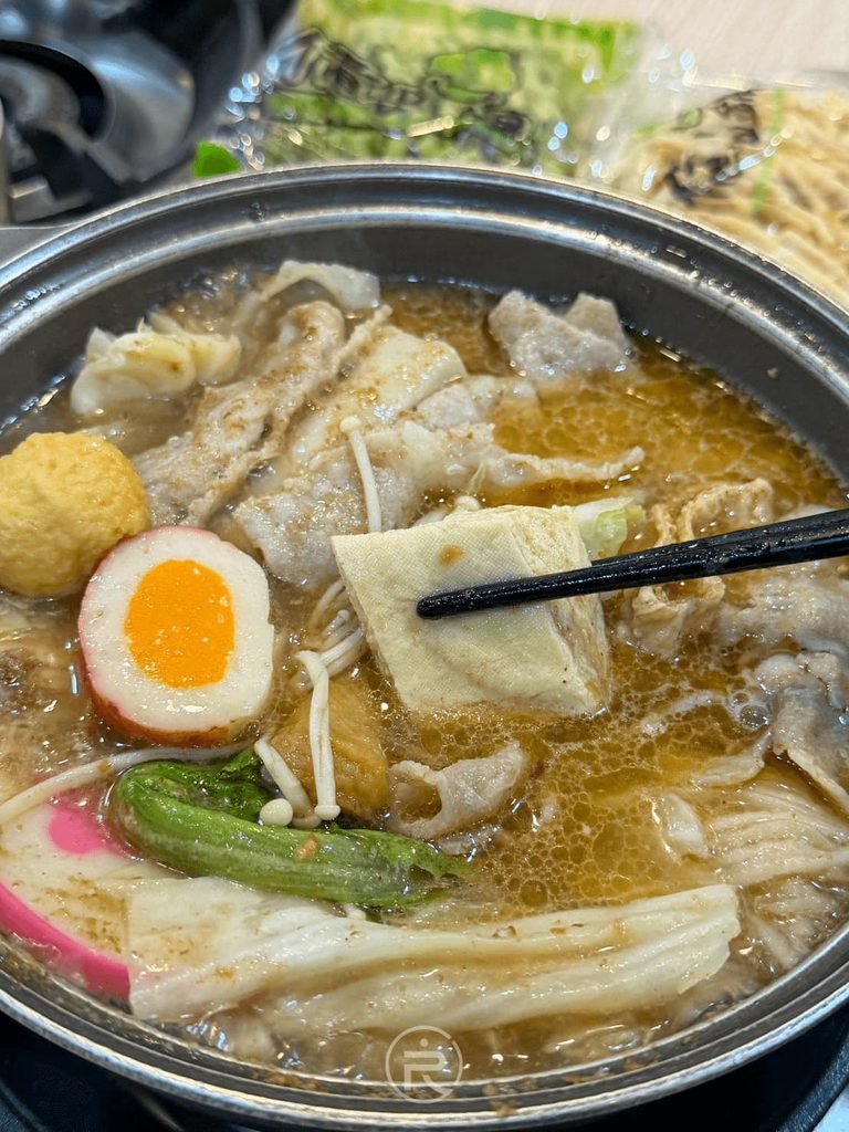 [夾起豆腐皮]： 筷子夾起鍋中吸滿沙茶湯汁精華的嫩豆腐皮。