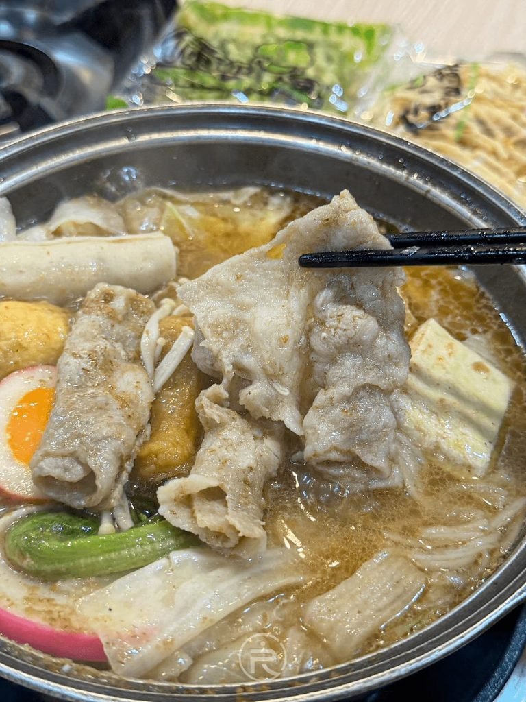  [夾起鮮嫩豬肉片]： 筷子夾起燙至軟嫩的豬五花肉片，油花分布均勻。