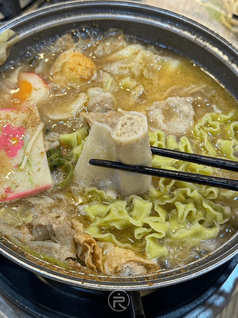  [夾起多汁豆皮]： 筷子夾起厚實多汁的火鍋豆皮，大口品嚐美味。