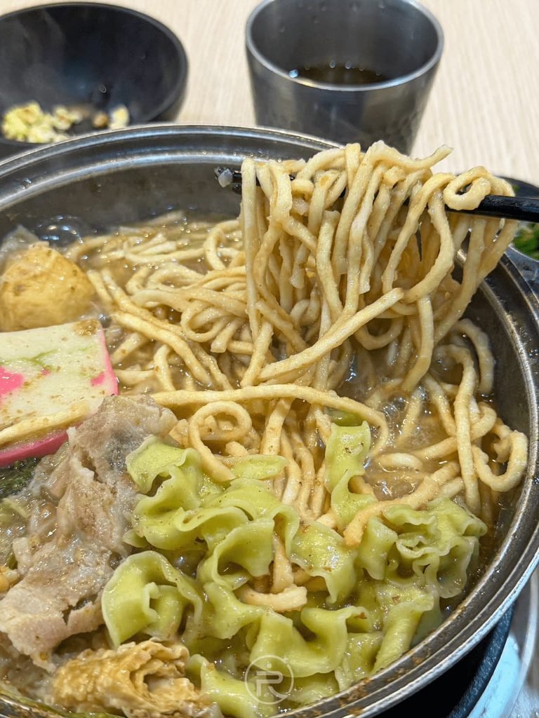 [筷夾雙色混合麵]： 筷子大把撈起吸滿沙茶精華的意麵與綠色波浪麵。
