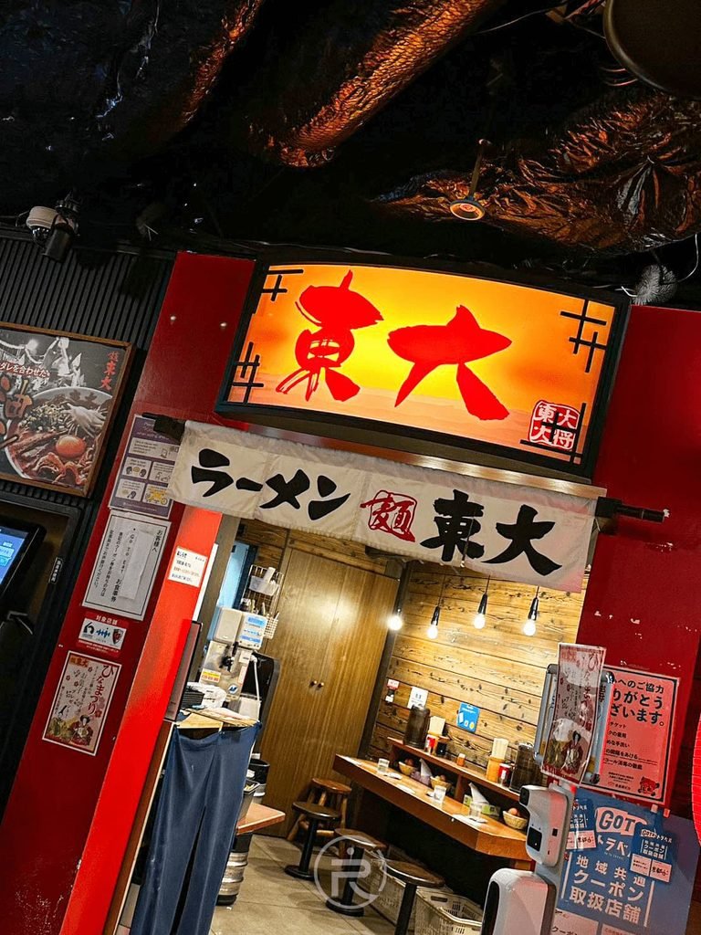[店面外觀街道]： 京都車站拉麵小路走廊上燈火通明的東大拉麵正門外景。