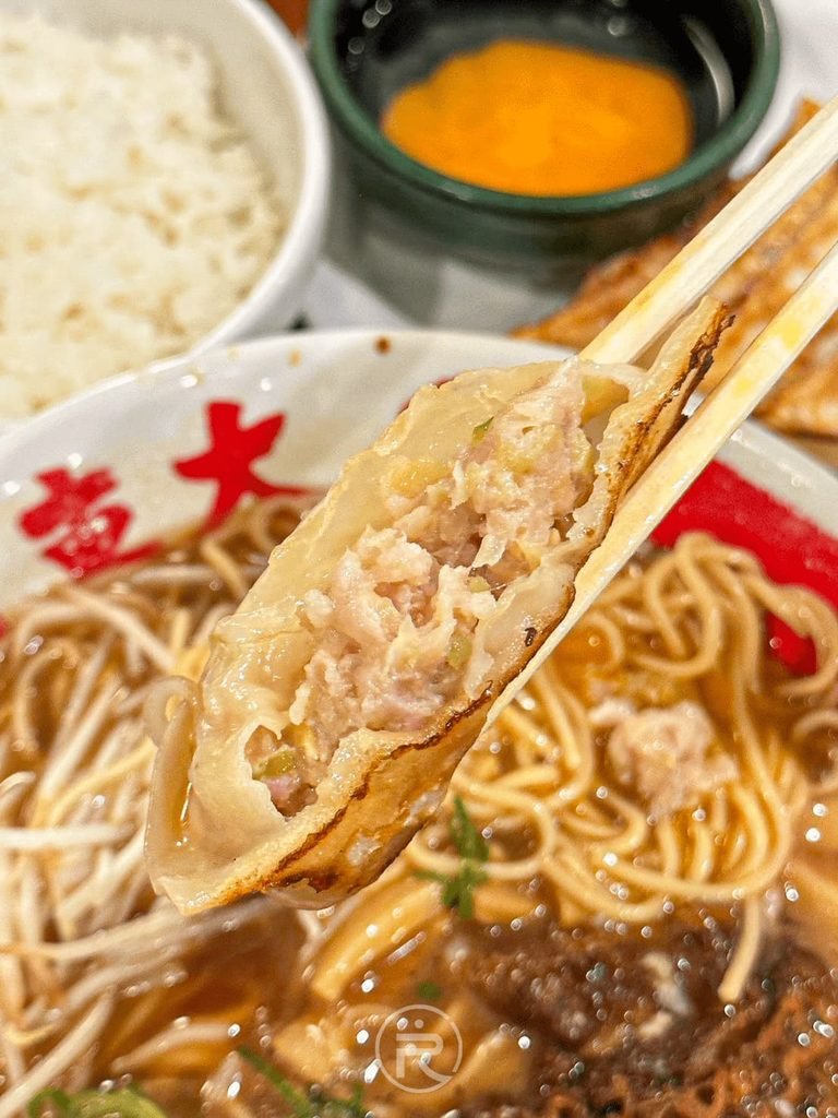  [咬開煎餃內餡]： 筷子夾起金黃現煎餃子，外皮酥脆、絞肉內餡飽滿多汁。