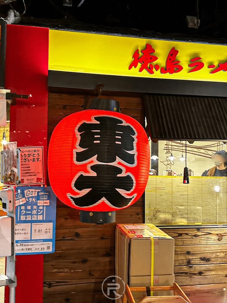 [外帶禮盒與紅燈籠]： 東大拉麵門口陳列的常溫伴手禮生麵盒裝與日式紅燈籠。