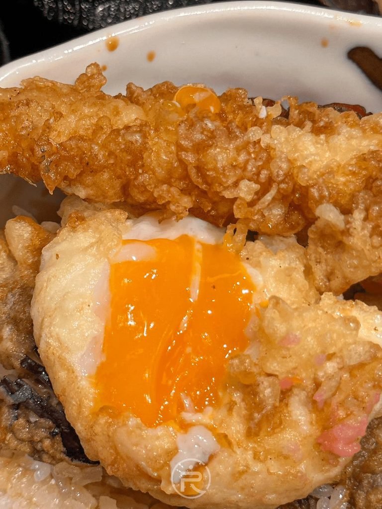  [流心蛋黃近拍]： 澄橘色半熟流心蛋黃特寫，是天丼白飯最完美的天然提味醬。