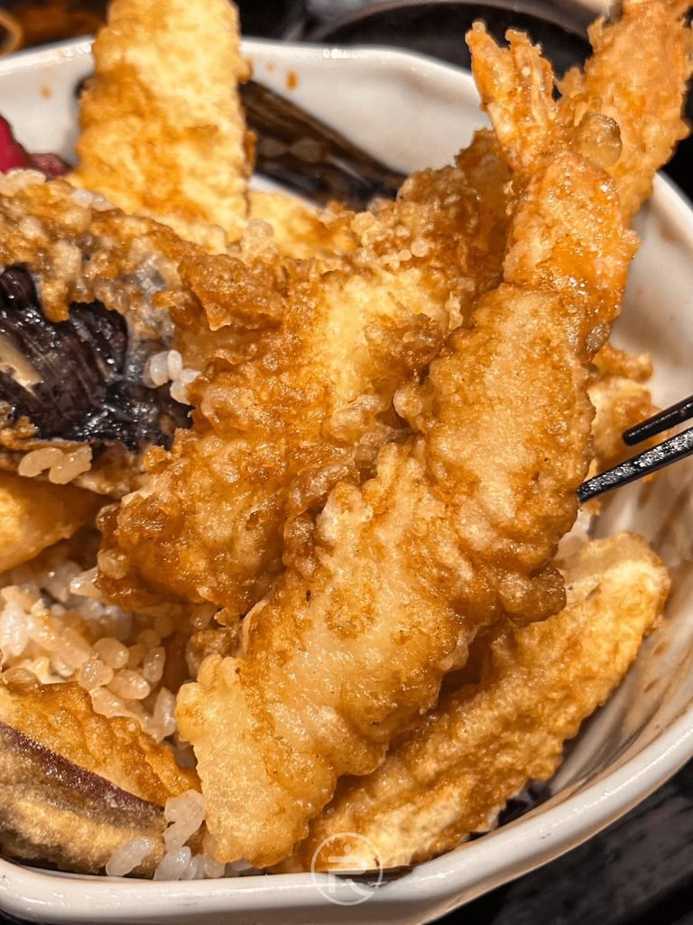 [炸蝦近拍特寫]： 炸至金黃酥脆的炸蝦天婦羅與炸茄子，淋上特製甜鹹天丼醬汁。